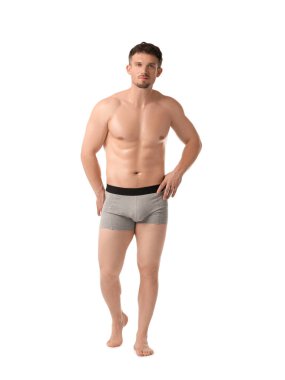 Beyaz arka planda açık gri iç çamaşırlı genç adam.