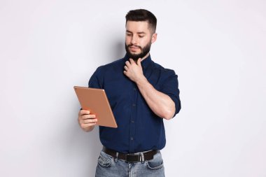 Yakışıklı adam beyaz zemin üzerine tablet kullanma