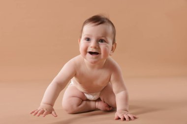 Bej arka planda emekleyen şirin bir bebek.