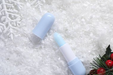 Nemlendirici dudak kremi ve yapay karla süslenmiş Noel süsü. Kış bakımı