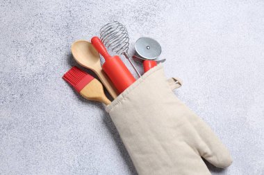 Farklı mutfak gereçleri fırın eldivenleri ışık masasında, yukarıda.