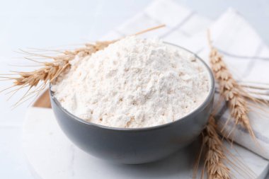 Buğday unu ve çiviler beyaz masada, yakın plan.