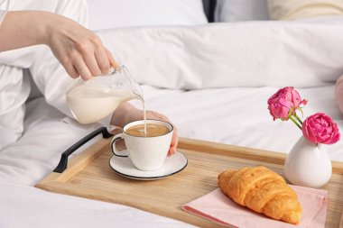 Kadın yatakta nefis bir kahvaltı yapıyor, yakın plan.