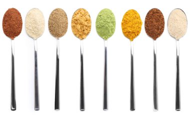 Beyaz arka planda kaşıklarda farklı süper yiyecek tozları, kolaj. Üst görünüm