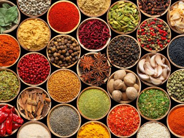 Siyah arka plandaki kaselerde farklı aromatik baharatlar dizisi.