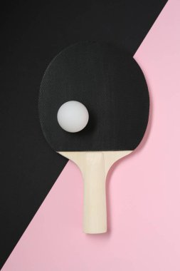 Renkli arka planda pinpon raketi ve top, üst görünüm