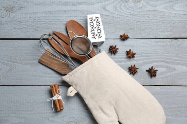 Farklı mutfak aletleri fırın eldiveni, tarçın ve yıldız anason açık gri ahşap masa, düz yatıyordu