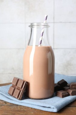 Cam şişede çikolatalı süt ve ahşap masada malzeme.