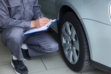 Tamirci araba servisinde değişiklik yaptıktan sonra lastikleri kontrol ediyor.