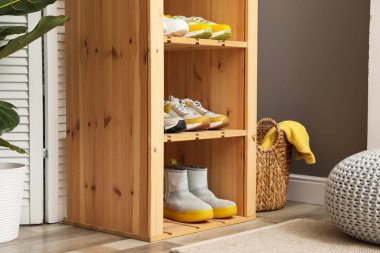 Girişteki raflarda farklı ayakkabılar var. Ayakkabı deposu