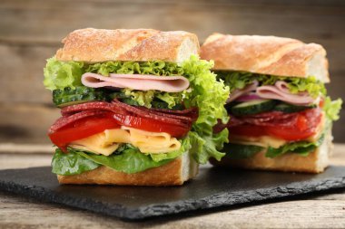 Tahta masada jambonlu ve sebzeli baget sandviç, yakın plan.