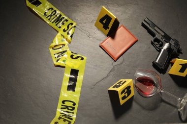 Adli tıp uzmanlığı. Gri arka planda delil, işaret ve polis bandı olan suç mahalli.