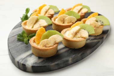 Meyveli tart ve beyaz mermer masada nane şekeri, yakın plan. Tatlı nefis.