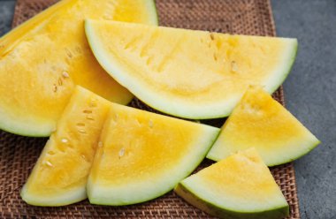 Masanın üzerinde olgun sarı karpuz parçaları, yakın plan.