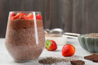 Açık gri masada chia tohumlu ve çilekli lezzetli çikolatalı puding, yakın plan. Metin için boşluk