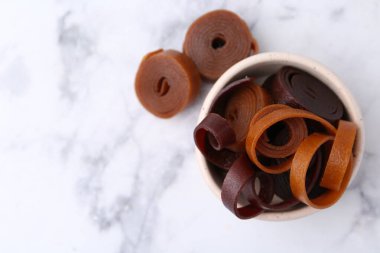 Lezzetli meyve derisi, beyaz mermer masada, üst manzaralı kâsede yuvarlanıyor. Metin için boşluk