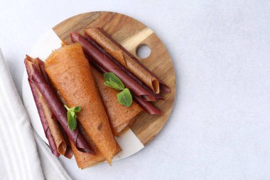 Lezzetli meyve dürümleri ve nane şekeri ışık masasında, üst manzara. Metin için boşluk