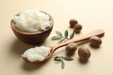 Tereyağı, fındık ve yapraklar bej arka planda, yakın plan