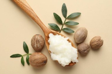 Tereyağı, fındık ve yapraklar bej arka planda, düz uzandı