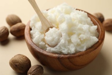 Bej arka planda doğal Shea yağı ve fındık, yakın plan.