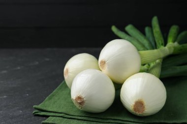 Taze taze soğan ve siyah masa üzerinde havlu, yakın plan. Metin için boşluk