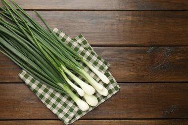 Taze taze taze soğan ve ahşap masa üzerinde havlu, üst manzara. Metin için boşluk