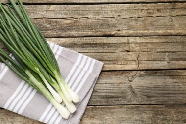 Taze taze taze soğan ve ahşap masa üzerinde havlu, üst manzara. Metin için boşluk