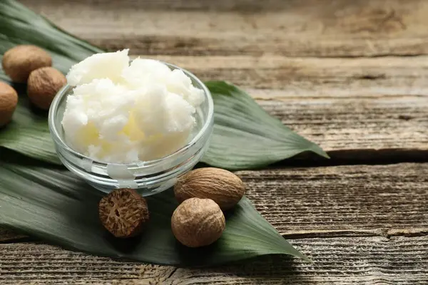 Doğal Shea tereyağı ve fındıklar ahşap masada, yakın plan. Metin için boşluk
