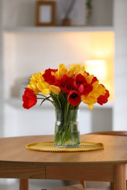 İçerideki ahşap masada vazodaki güzel laleler.