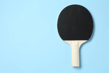 Açık mavi arka planda pinpon raketi, üst manzara. Metin için boşluk