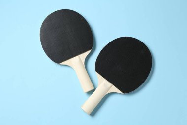 Açık mavi zemin üzerinde pinpon raketleri, düz yatıyordu