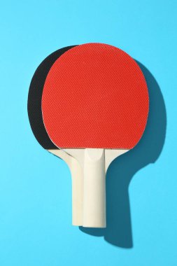 Mavi arkaplanda pinpon raketleri, üst görünüm