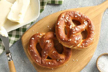 Tuz ve tereyağlı lezzetli krakerler açık gri masada, düz yerde.