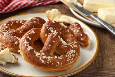 Ahşap masada tuz ve tereyağlı lezzetli krakerler, yakın plan.