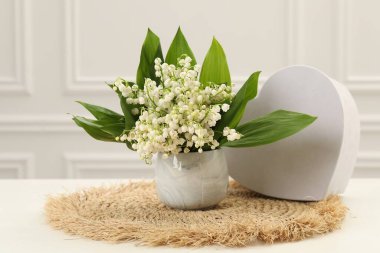 Vadi çiçeklerinin güzel zambakları ve beyaz masada kalp şeklinde hediye kutuları.