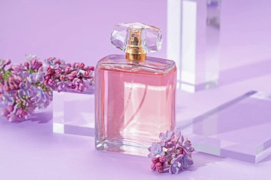 Mor arka planda parfüm şişesi ve leylak çiçeklerinin şık sunumu, yakın plan.