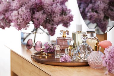 Parfümlü şişeler, leylak çiçekleri ve kapalı soyunma odasındaki aksesuarlar.