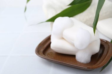 Beyaz masadaki köpüklü sabun çubukları, yakın plan. Metin için boşluk