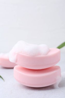 Beyaz masadaki köpüklü sabun çubukları, yakın plan. Metin için boşluk