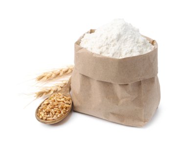 Kese kağıdında buğday unu, beyaz arka planda tahıl ve çiviler.