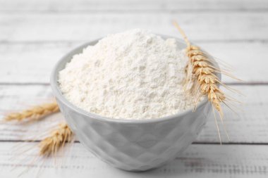 Buğday unu kasede ve çiviler açık tahta masada, yakın plan.