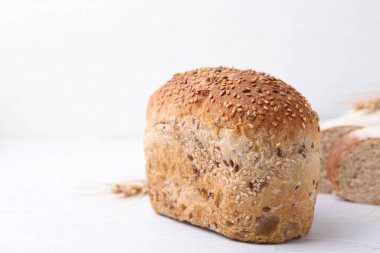 Taze pişmiş somun ekmek ve ışık masasında susam tohumu, yakın plan. Metin için boşluk