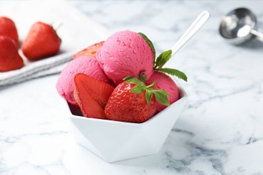 Tazeleyici şerbet, çilek ve nane şekeri beyaz mermer masada, yakın plan.