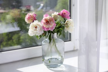 Pencere pervazında vazoda güzel şakayıklar.