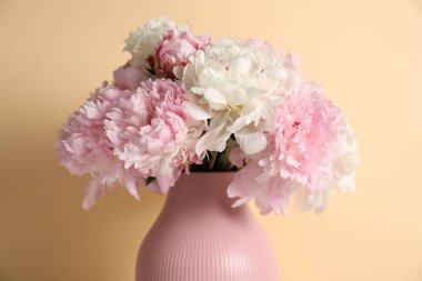 Bej arkaplanda vazodaki güzel şakayıklar, yakın plan