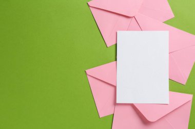 Boş davetiye kartı ve yeşil arka planda zarflar. Tasarım için boşluk