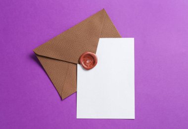 Mor arka planda boş davetiye ve zarf, üst manzara. Tasarım için boşluk