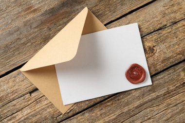 Üzerinde balmumu mühür ve ahşap masa manzaralı boş bir davetiye kartı. Tasarım için boşluk