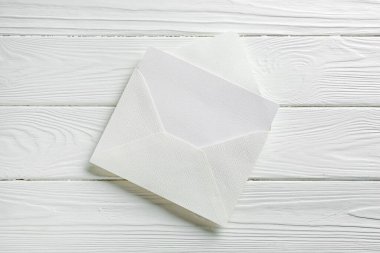 Boş davetiye kartı ve zarf beyaz ahşap masa, üst görünüm
