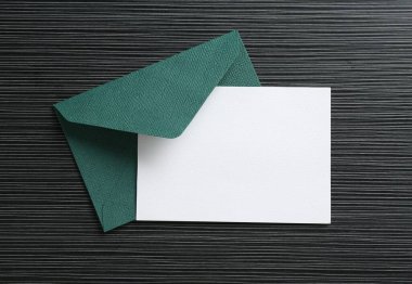 Siyah desenli masa üzerinde boş davetiye ve zarf, üst manzara. Tasarım için boşluk